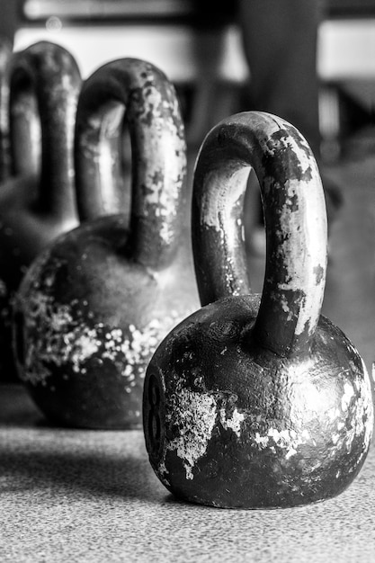 Vieux poids et haltères dans la salle de gym sur le sol.