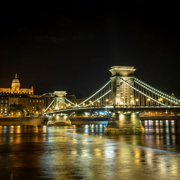 Le vieux pont de fer la nuit à la lumière des lampadaires sur le Danube à Budapest, en Hongrie