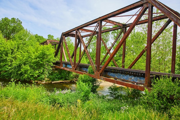 Vieux pont ferroviaire traversant la forêt avec la rivière Kokosing