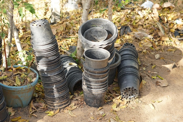 Vieux pots de plantes empilés les uns contre les autres sur le mur