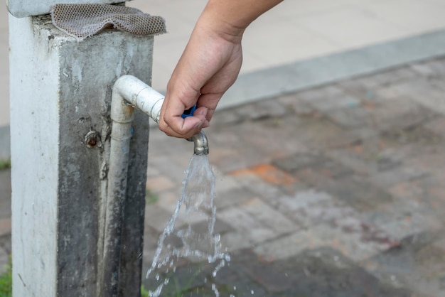 Le vieux robinet et la main sont en eau libre