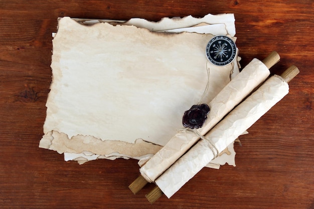 Vieux rouleaux de papier et boussole sur fond de bois