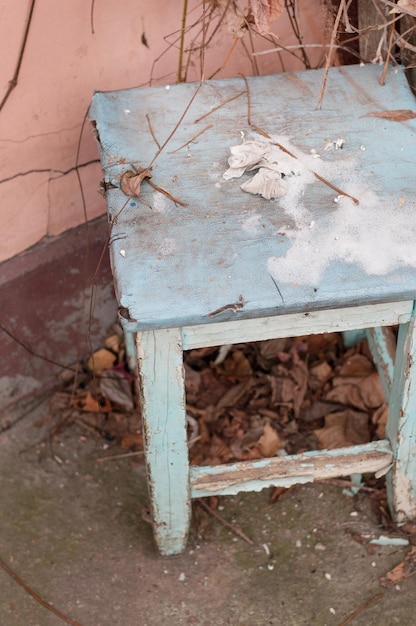 Vieux tabouret bleu en bois sur un gros plan de fond de mur rose