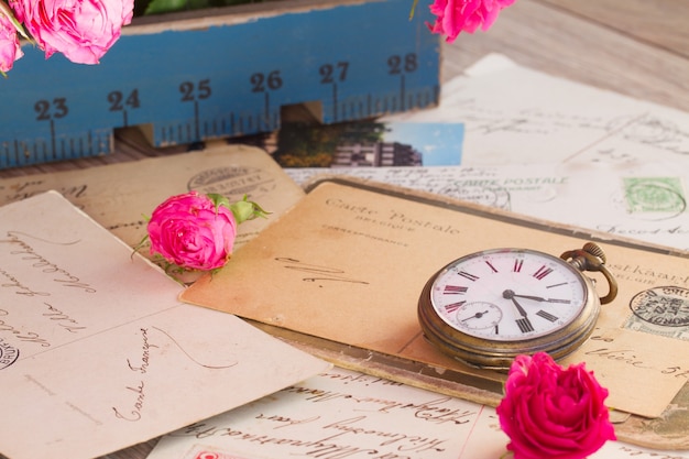 Vieux tas de courrier et horloge antique sur table en bois