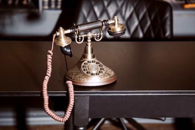 Vieux téléphone chandelier antique vintage sur la table de travail d'entreprise travaillant sur le passé.