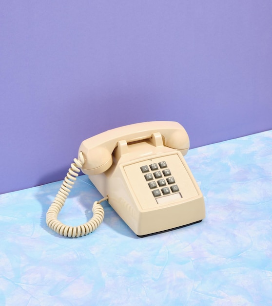 Vieux téléphone vintage beige avec boutons gris sur la table Style rétro et esthétique Communication téléphonique