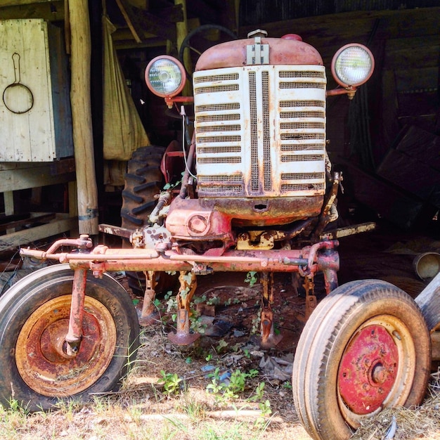 Photo vieux tracteur abandonné dans un hangar