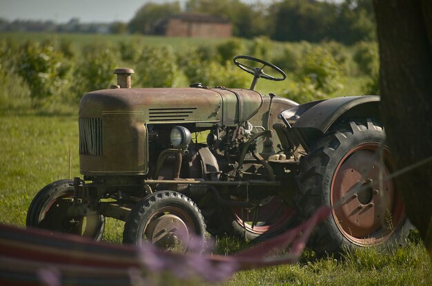 Vieux tracteur agricole rouillé et ruiné des heures de travail faites au cours des 50 dernières années. Symbole de la vie active dans les champs.