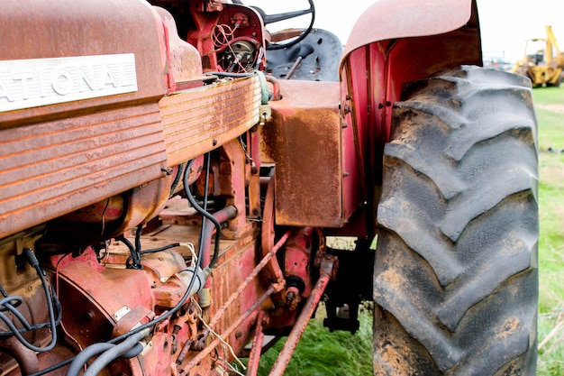 Vieux tracteur sur un champ herbeux