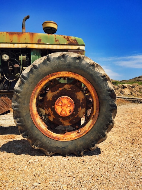 Photo vieux tracteur rouillé sur le champ contre le ciel