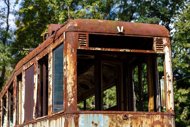 Vieux tram abandonné rouillé en plein air à la journée ensoleillée.