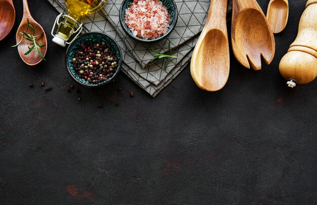 Vieux ustensiles de cuisine en bois et épices comme une frontière sur un fond noir