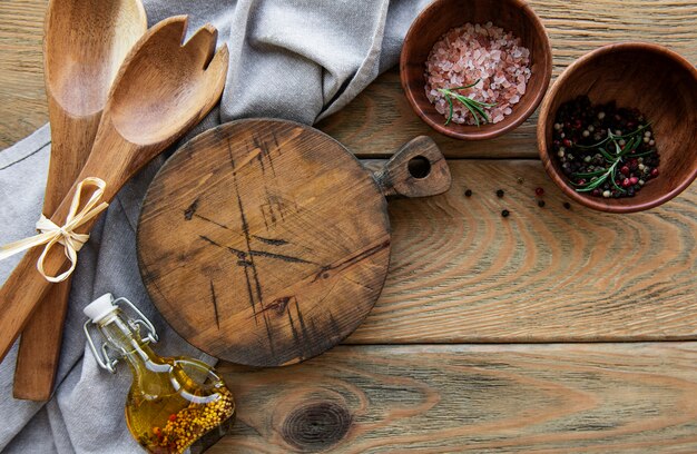 Vieux ustensiles de cuisine vintage. Cuillères en bois, planche à découper, serviette et épices sur la vieille table en bois. Vue de dessus