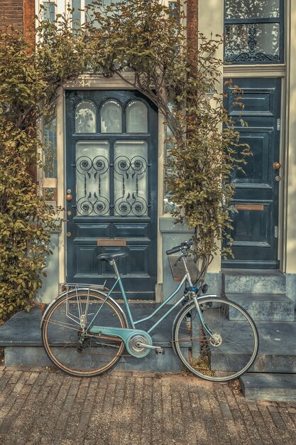 Vieux vélo devant une maison