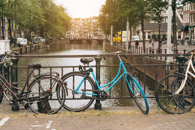 Vieux vélo sur le pont à Amsterdam Pays-Bas contre un canal pendant la journée ensoleillée d'été Vue emblématique de la carte postale Concept de tourisme