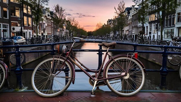 Photo vieux vélos sur le pont d'amsterdam aux pays-bas contre un canal au crépuscule d'été au coucher du soleil