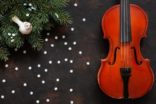 Vieux violon et branches de sapin avec un décor de Noël.