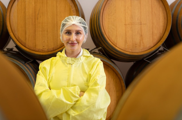 Une vigne souriante en uniforme jaune se tient dans la cave de la cave