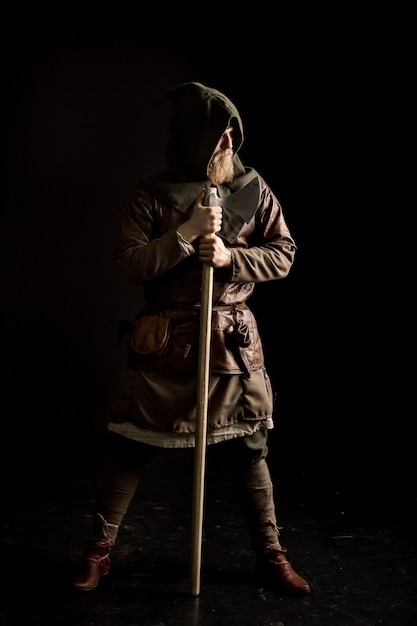 Photo viking avec une hache sur un fond noir
