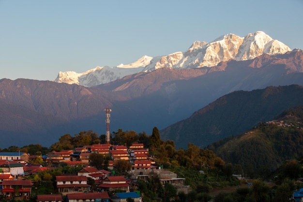 Un village dans les montagnes avec des montagnes enneigées en arrière-plan