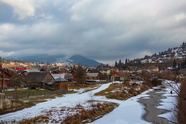 Village d'hiver dans les montagnes au bord d'une petite rivière