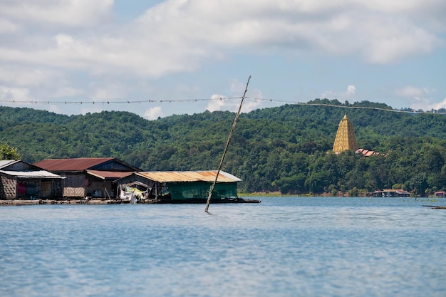 Photo village de maisons flottantes sur la rivière songaria avec la pagode bodhgaya à sangkhlaburi kanchanaburi