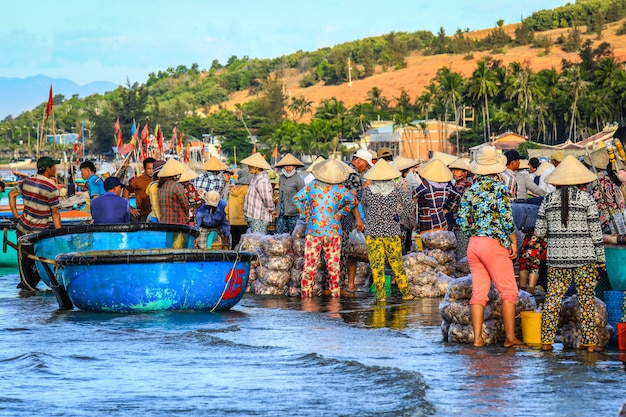 Village de pêcheurs tôt le matin à Mui ne, plein de vendeurs vietnamiens sur la plage