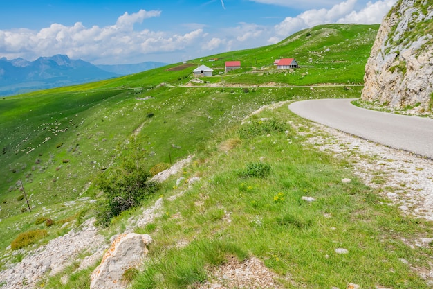 Le village pittoresque est parmi les prairies sur les hautes montagnes.