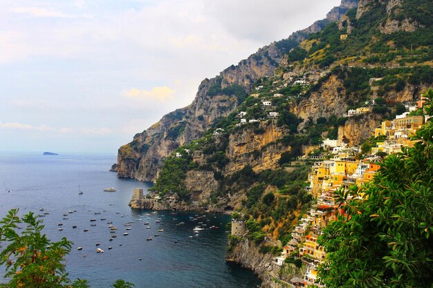 Photo le village de positano sur la montagne par la mer contre le ciel