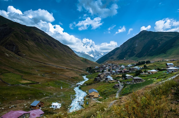 Village Ushguli paysage avec d'énormes montagnes rocheuses mur de Bezengi, Shkhara sur l'arrière-plan à Svaneti, Géorgie