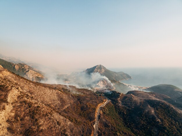 La ville sur la côte du Monténégro est engloutie dans le feu de la fumée blanche sur la ville la route et le