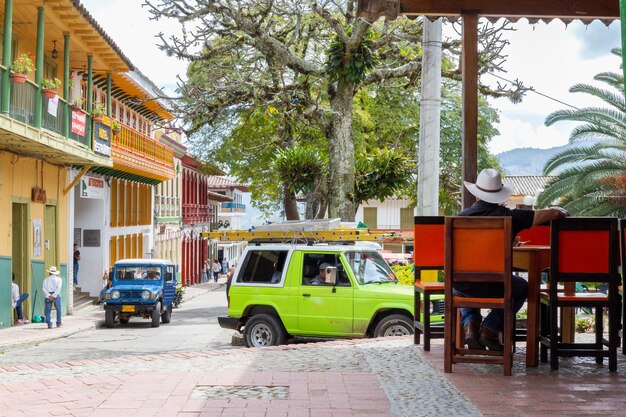 Ville dans les montagnes colombiennes où se trouvent diverses voitures colorées et des habitants locaux