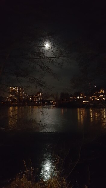 Photo une ville éclairée par la mer contre le ciel de nuit