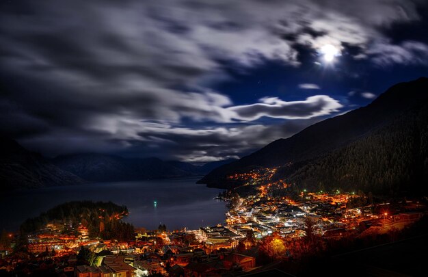 Photo une ville est éclairée par la lune et la lune brille