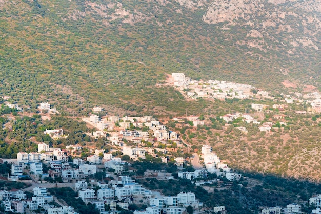 Ville à la façade blanche et aux toits de tuiles rouges dans les montagnes