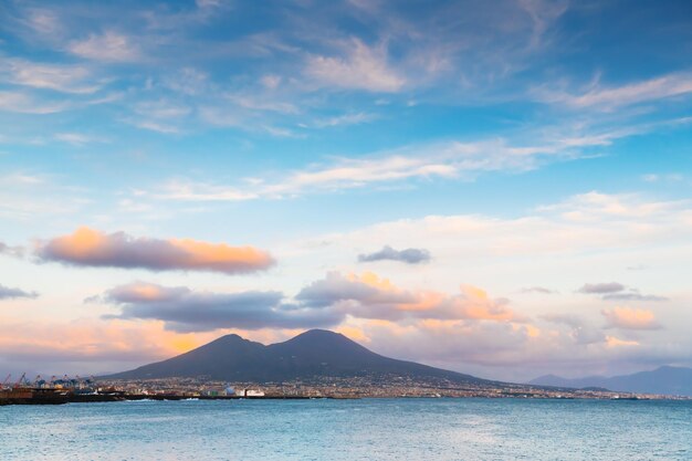 Photo la ville de naples et le golfe de naples italie le volcan vésuve avec des nuages roses au coucher du soleil