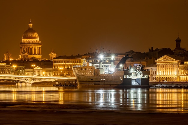 la ville de nuit d'hiver Saint-Pétersbourg avec une réflexion pittoresque sur l'eau est amarrée grand navire