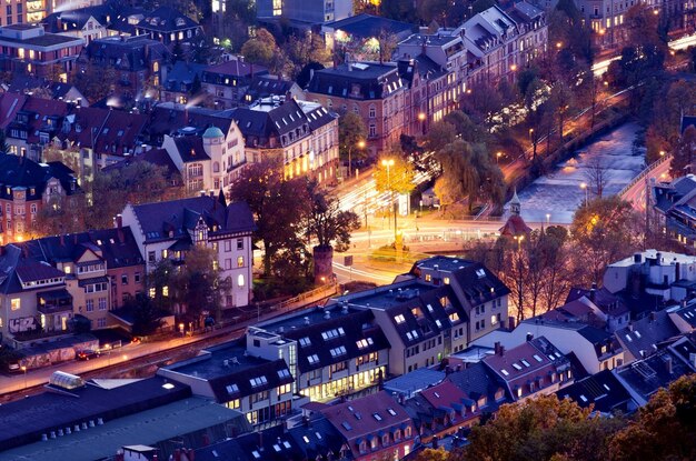 une ville la nuit avec une rue avec des maisons et une lumière de rue