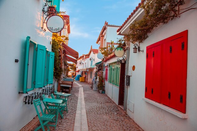 Ville de villégiature, rue latérale douce et colorée en été. Des chaises vertes sont à l'entrée de la rue,