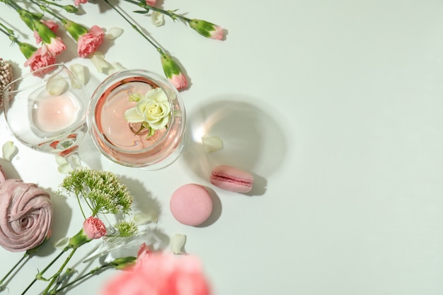 Vin, aliments sucrés et fleurs sur tableau blanc