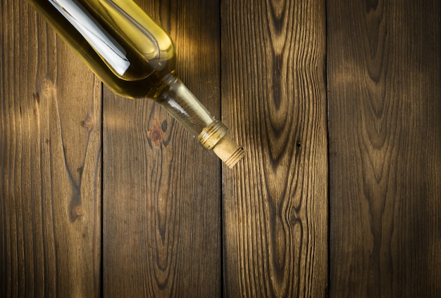 Vin blanc avec des branches de raisins blancs. Sur une table en bois.