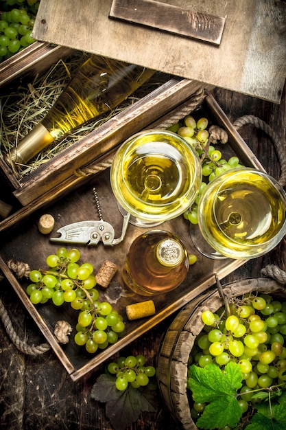 Vin blanc dans des verres sur table en bois.