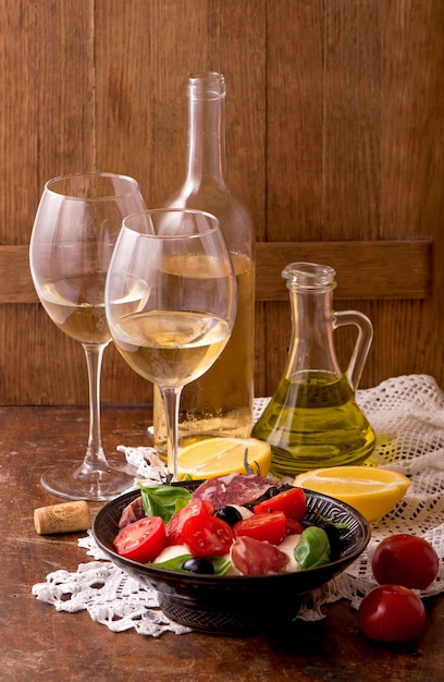 Vin blanc et tomates au basilic Vin et tomates au basilic dans un décor vintage sur table en bois