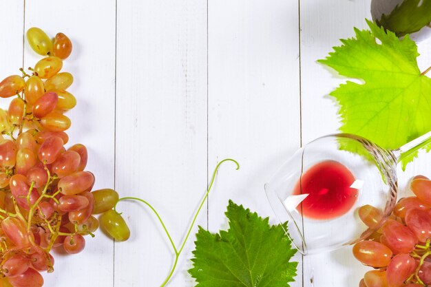 Vin avec des branches de raisins blancs. Sur une table en bois