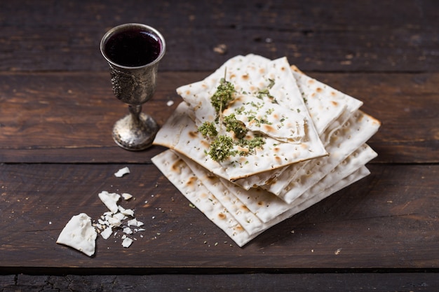 Vin casher rouge avec une matsa blanche ou matsa sur un mur en bois vintage présenté comme un repas du seder de Pâque avec copie espace.