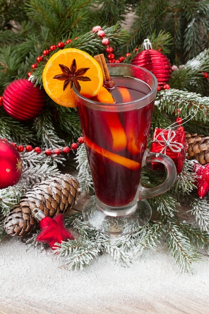 Vin chaud avec arbre de Noël décoré dans la neige