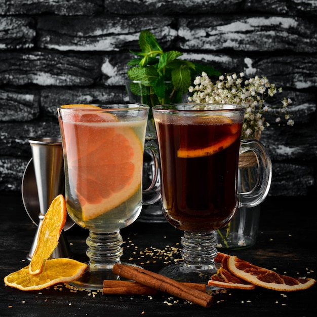 Vin chaud aux agrumes Cocktails traditionnels d'hiver et d'automne Sur un fond en bois noir Espace de copie gratuit Vue de dessus