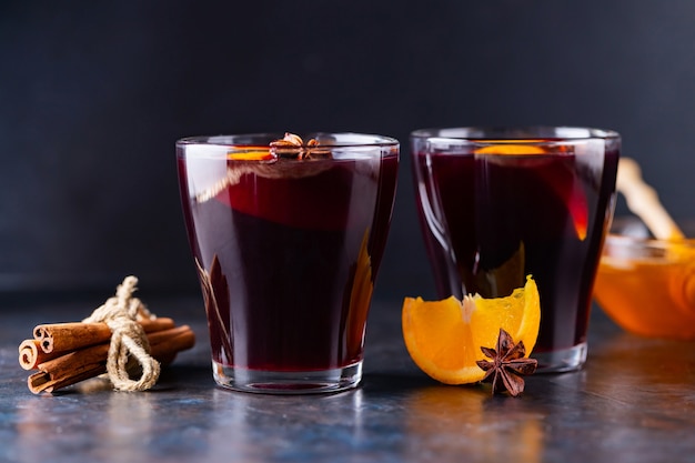 Vin chaud aux épices et orange dans des tasses en verre