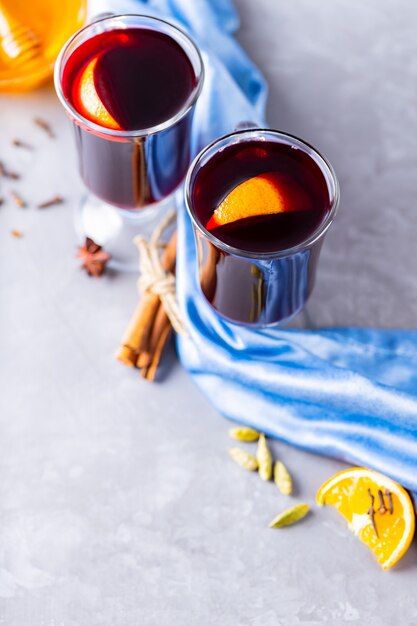 Vin chaud aux épices et orange dans des tasses en verre