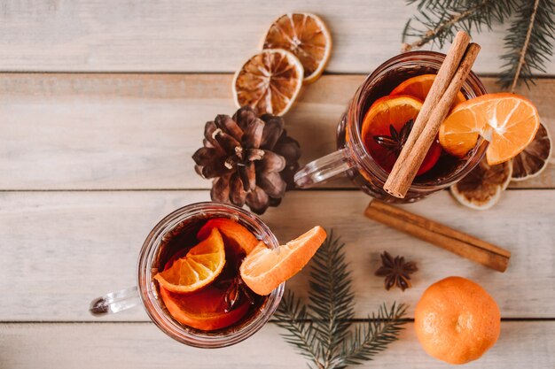 Vin chaud aux fruits et épices sur fond de bois Boisson réchauffante d'hiver pour les vacances